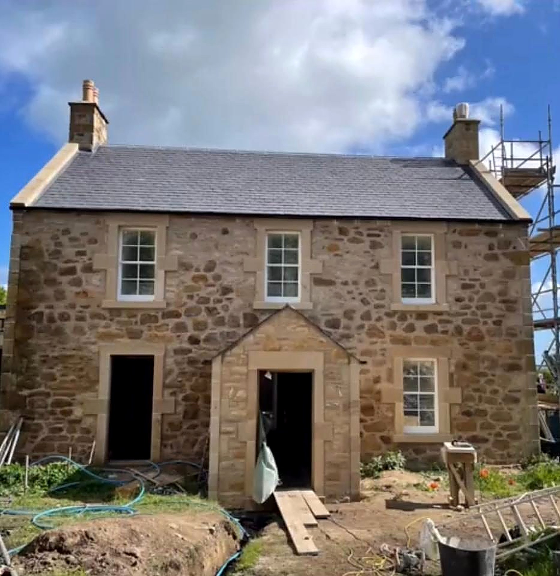 Newly built sandstone house with chimneys by A1 Masonry